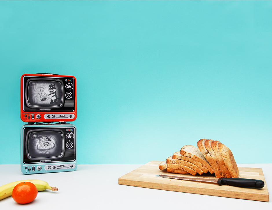 Orange and blue tv lunchboxes with fruit and bread board