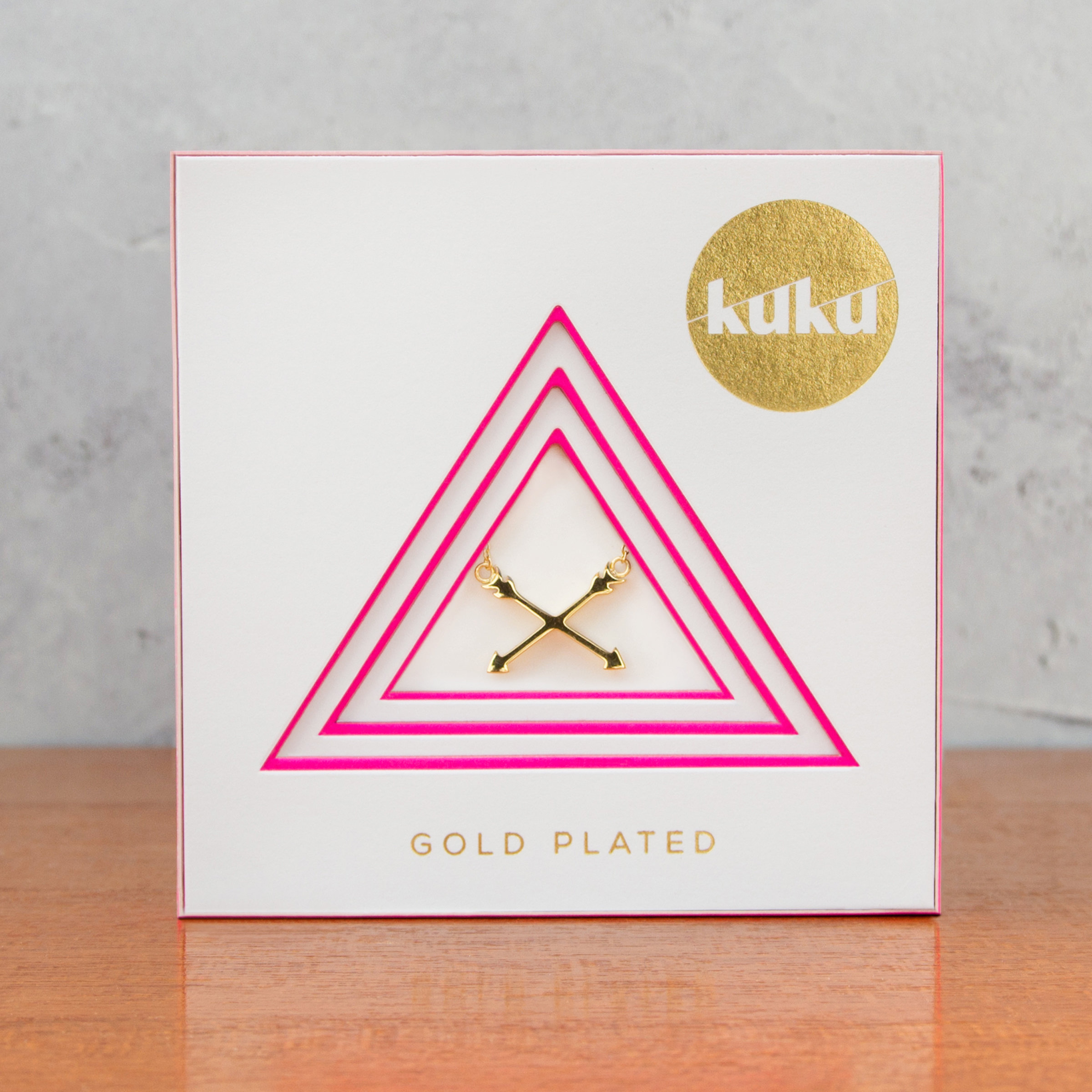 Kuku gold arrow necklace in packaging