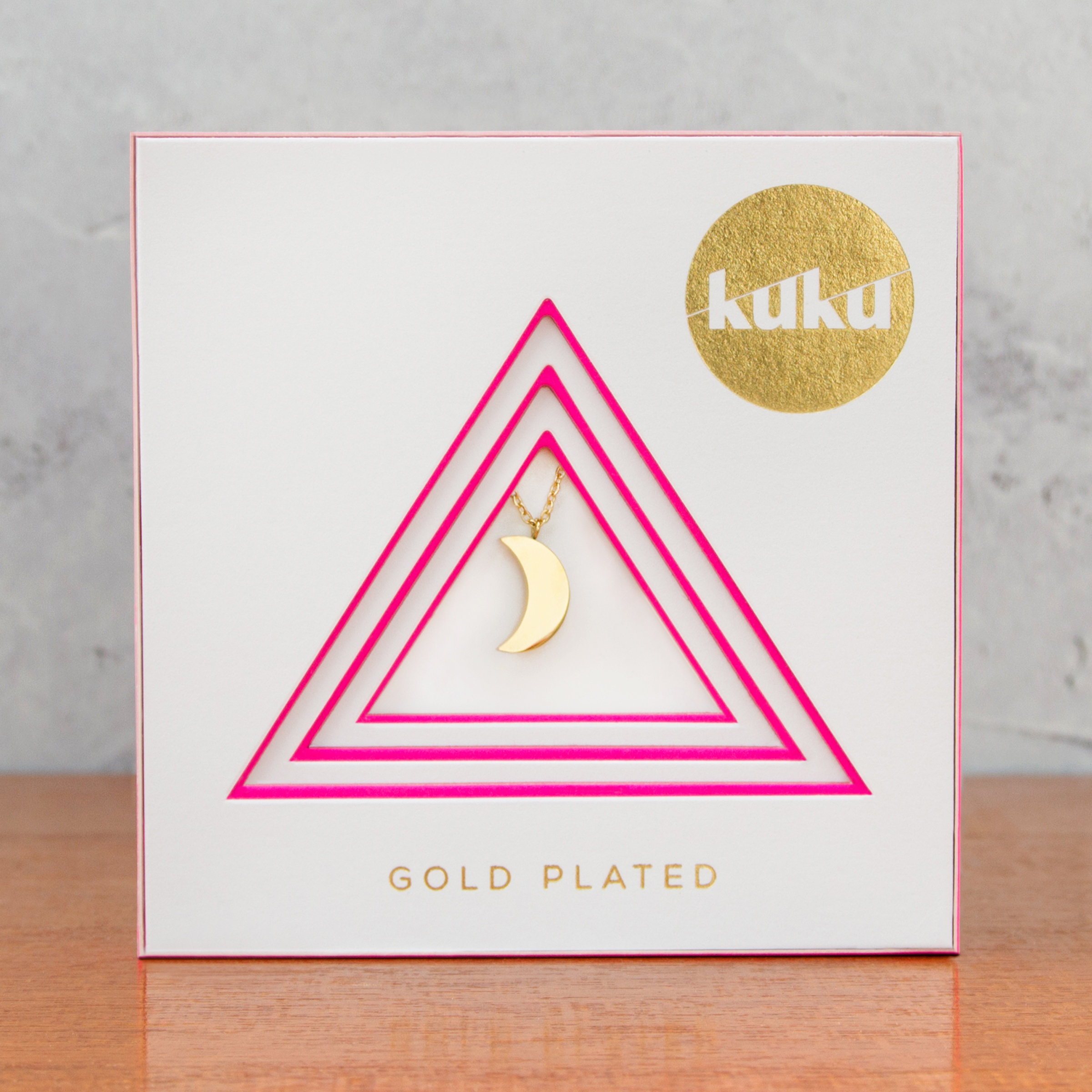 Kuku gold crescent moon necklace in packaging