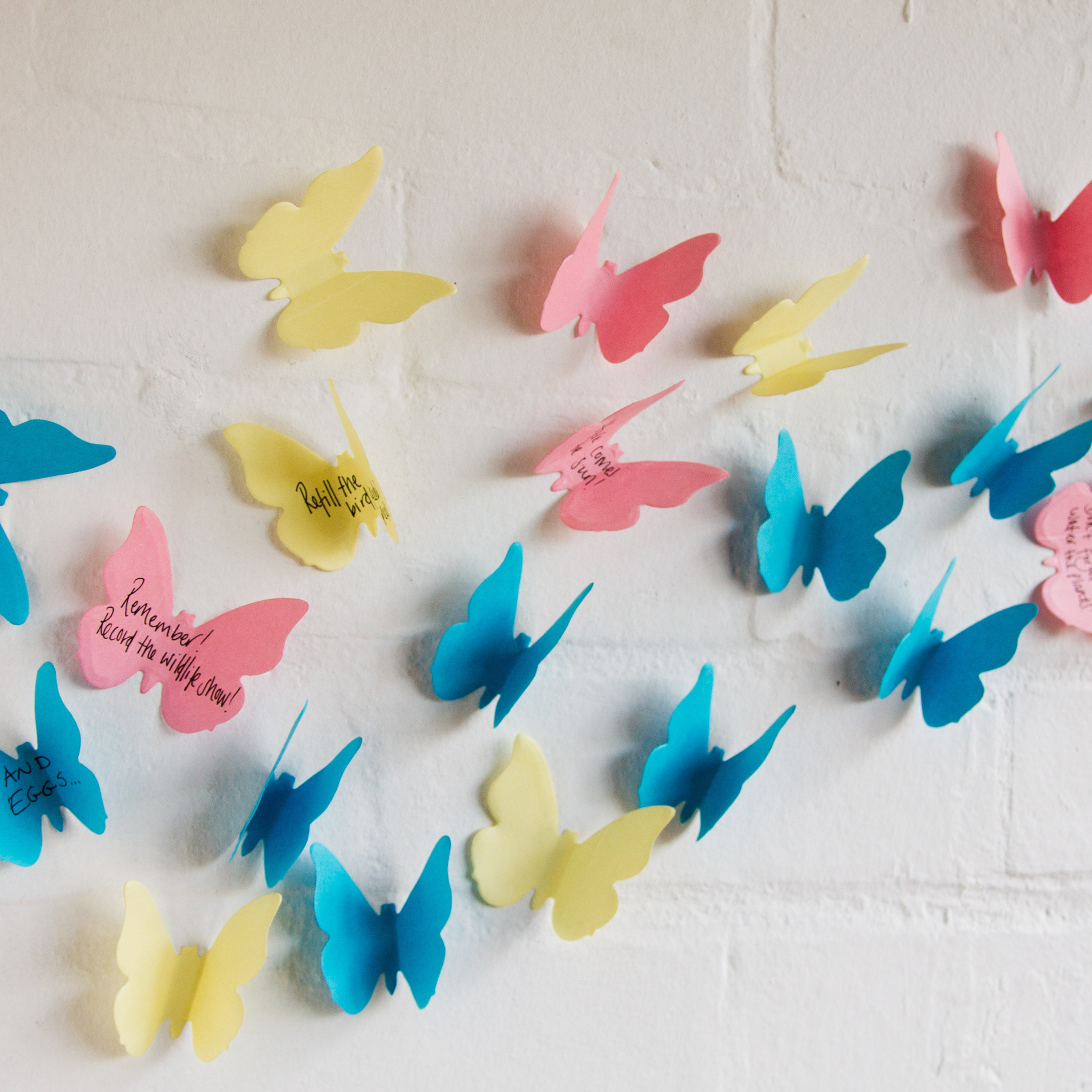 Butterfly sticky notes on a wall with memos