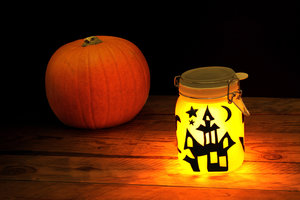 Halloween sun jar on a table next to pumpkin