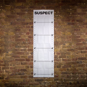 Mugshot height chart on a brick wall with feet and inches