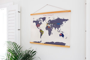 cross stitch map on a white wall with window shutters