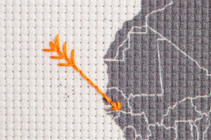 embroidered world map arrows close up