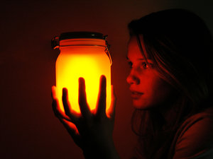 girl holding mason jar in the dark