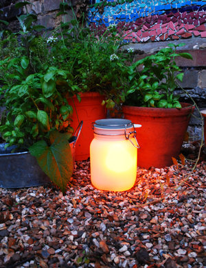 glow jars in the garden near flower pots
