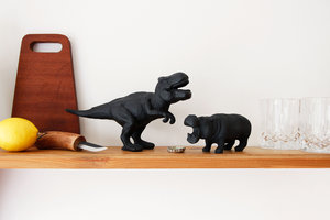 dinosaur and hippo cast iron bottle opener on shelf