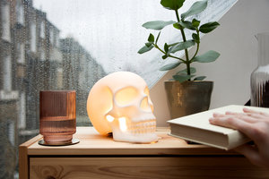 Skull lamp with hand taking book 