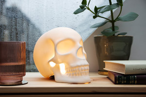 Close up view of Skull table lamp on bedside table with rain on the window