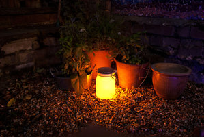 solar light jar in garden darker