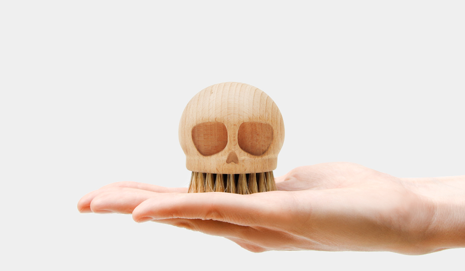 Wooden Skull Brush in palm of hand
