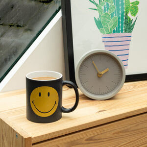 A mug of tea with a yellow Smiley Face