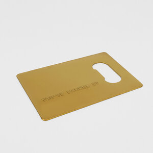 gold credit card bottle opener on grey background