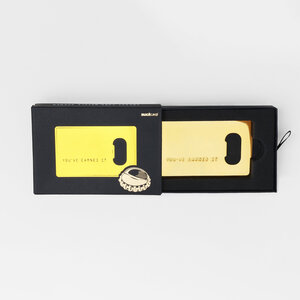 gold credit card bottle opener opened black box on grey background