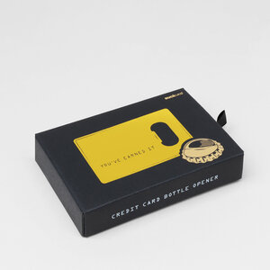 gold credit card bottle opener black box on grey background