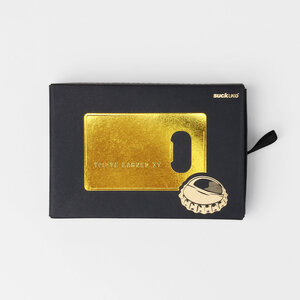 gold credit card bottle opener black box on grey background