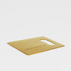 gold credit card bottle opener on grey background