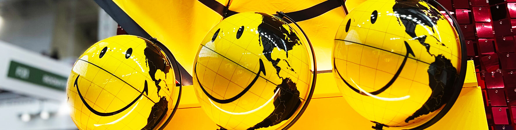 SuckUK's yellow Smiley globes on display at Top Drawer 2025, part of the licensed Smiley gift collection