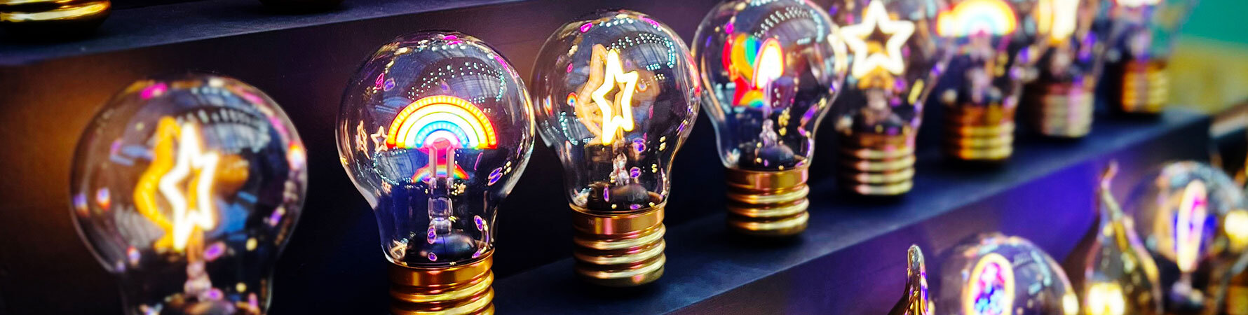 Close-up of SuckUK's rainbow and star light bulb gifts on display at Top Drawer 2025