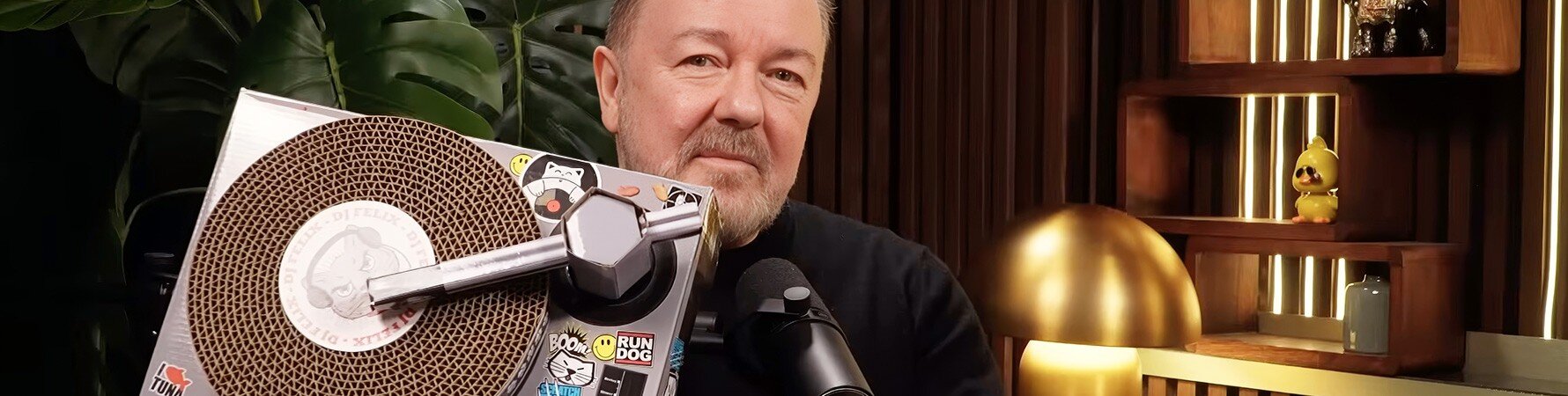 Ricky Gervais holding the Cat Scratch Turntable gift on The Romesh Ranganathan Show