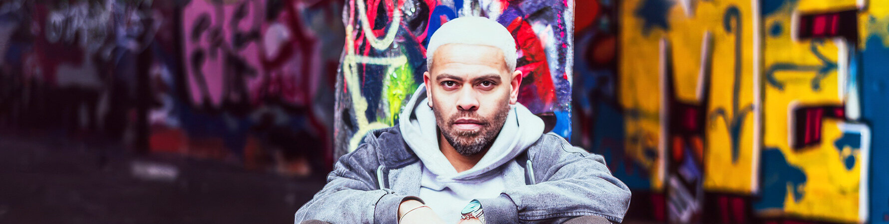 Lukas Setto UK soul artist portrait in front of colourful graffiti wall
