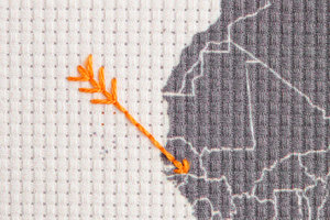 embroidered world map arrows close up
