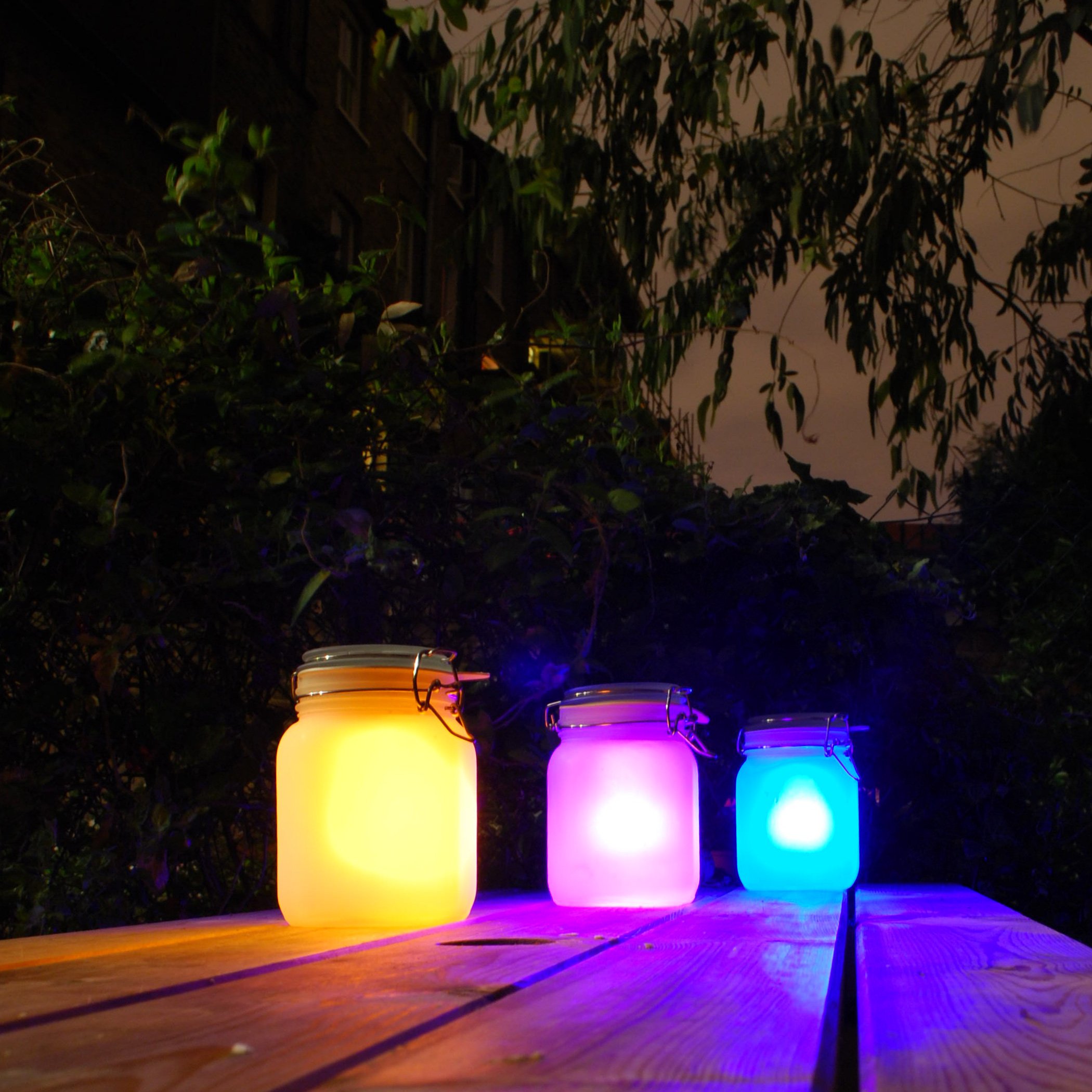 3 Sun Jars on a table at night