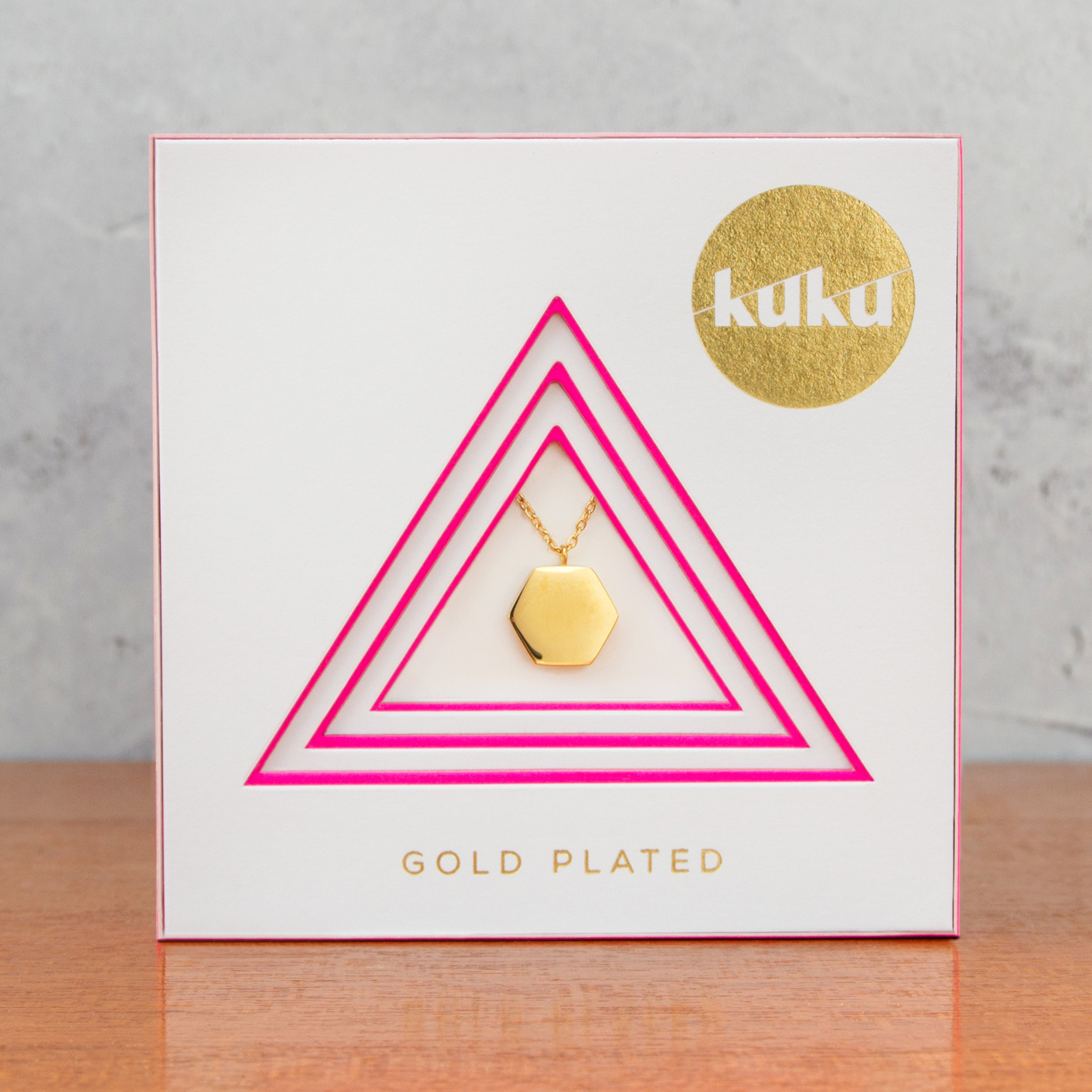Kuku gold hexagon necklace in packaging
