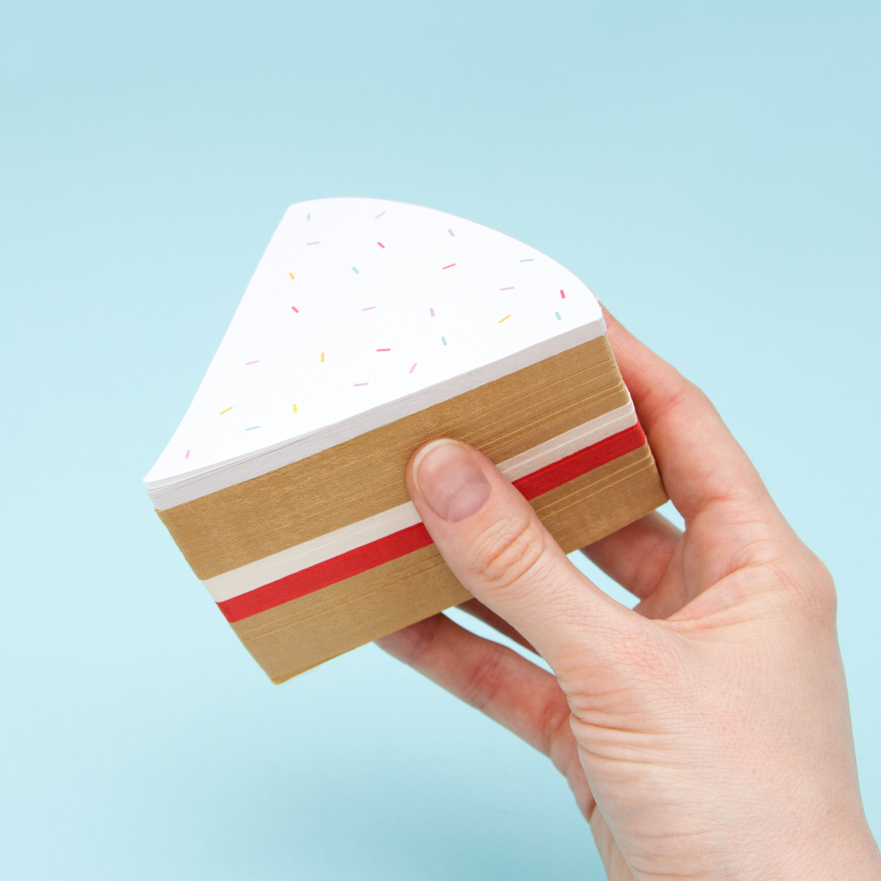 Slice of cake memo pad in hand