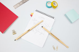 Black drumstick pens on notebook on desk