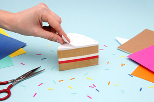 Hand peeling top layer of cake memo pad