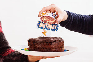 Birthday cake with neon sign on top.