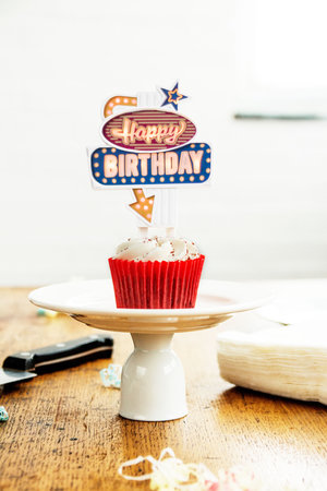 Cup cake with neon sign on top.