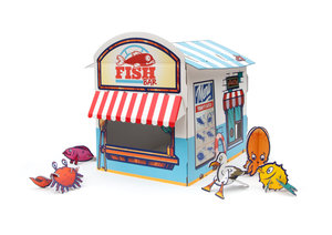 Cardboard cat playhouse with beach themed toys on a white background