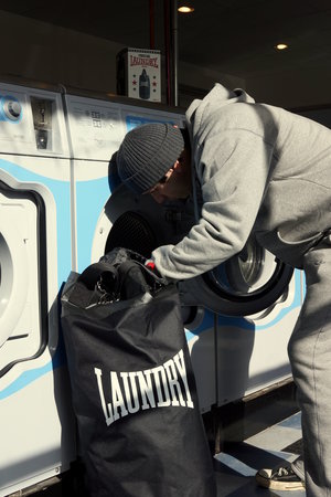 man removing clothers from cheap punch bag 