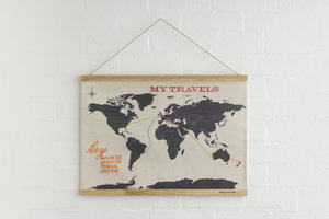 cross-stitch world map hung on white wall