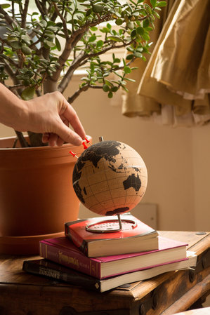 hand pinning tack to globe gift