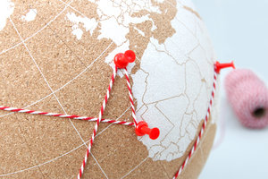 Globe made of cork with pushpins to pinpoint destinations