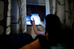 kid holding light jar indoors at night