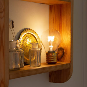 atmospheric glowing light bulb on wooden shelf