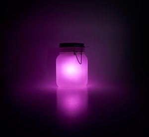 pink glowing jars in a dark room
